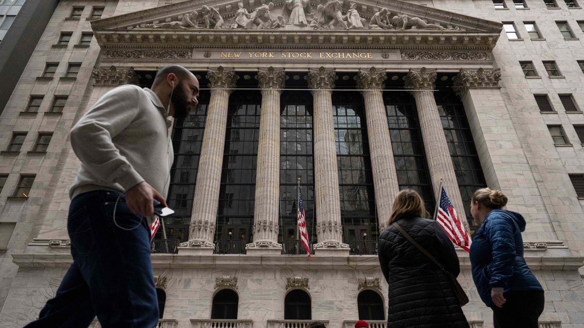 People walk past the New York Stock Exchange, Friday, March 27, 2026, in New York. (AP Photo/Yuki Iwamura)