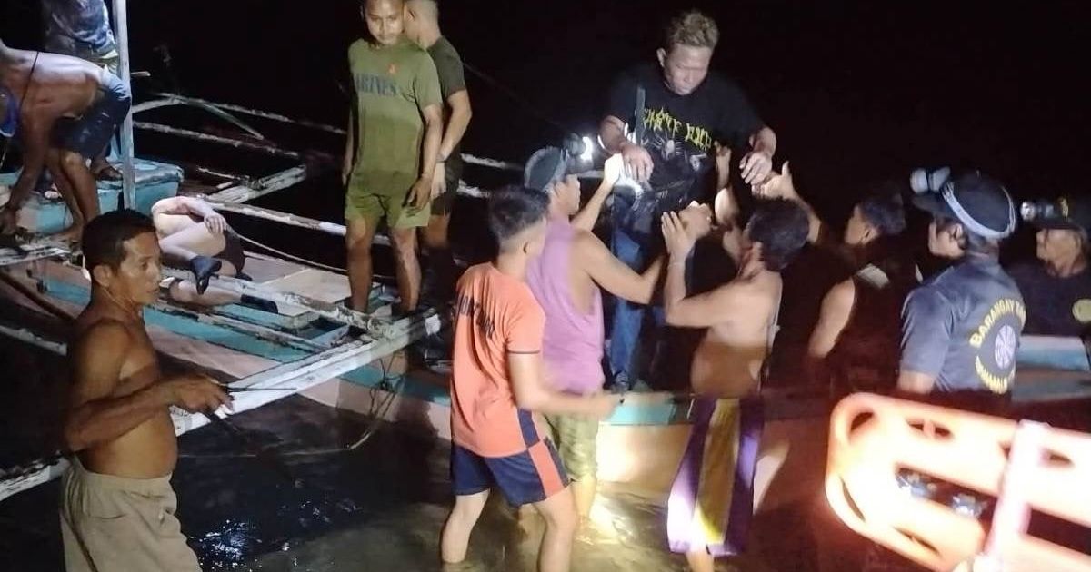 In this image provided by the Philippine Coast Guard, a survivor is assisted as he alights from a small boat after being