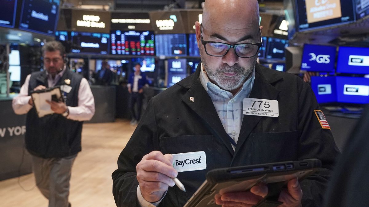 Trader Fred Demarco, right, works on the floor of the New York Stock Exchange, Friday, Feb. 13, 2026, in New York. (AP Photo/Richard Drew)