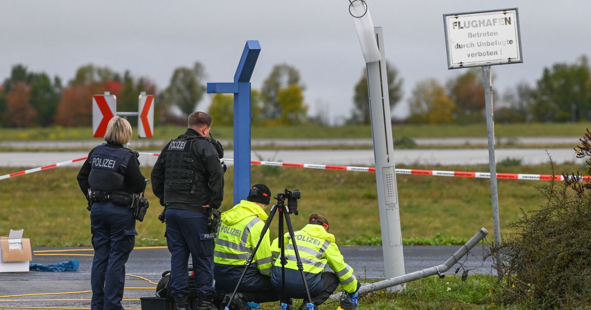 German police say 2 men turned themselves in after smashing their car into an airport fence