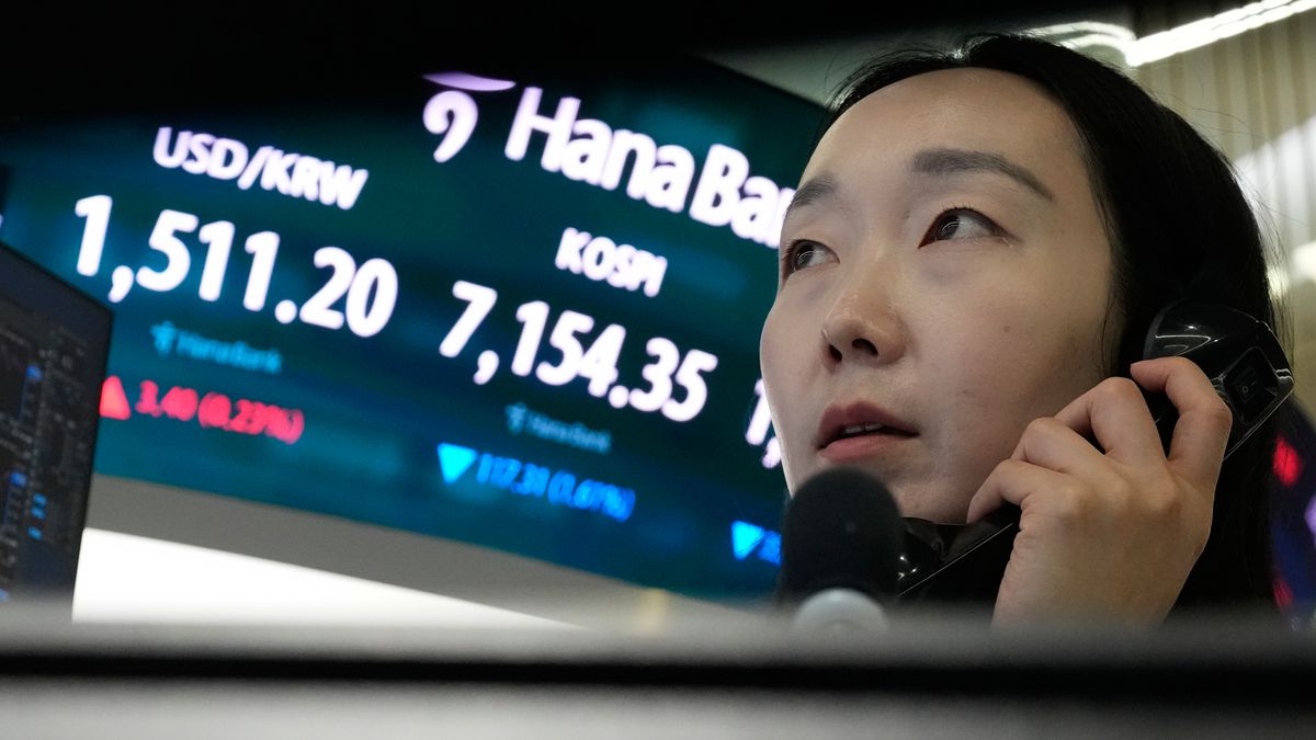 A currency trader talks on the phone near a screen showing the Korea Composite Stock Price Index (KOSPI) and the foreign exchange rate between U.S. dollar and South Korean won, left, at the foreign exchange dealing room of the Hana Bank headquarters in Seoul, South Korea, Wednesday, May 20, 2026. (AP Photo/Ahn Young-joon)