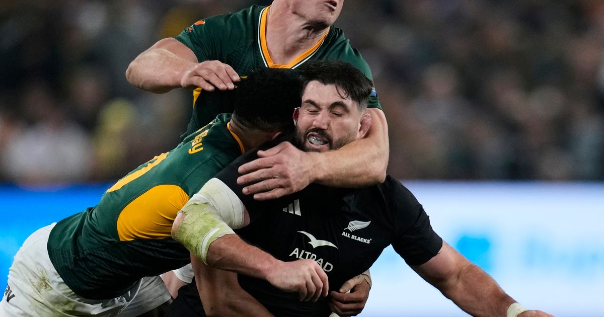 New Zealand's Luke Jacobson, right, is tackled by South Africa's Sacha Feinberg-Mngomezulu, left, and his teammate