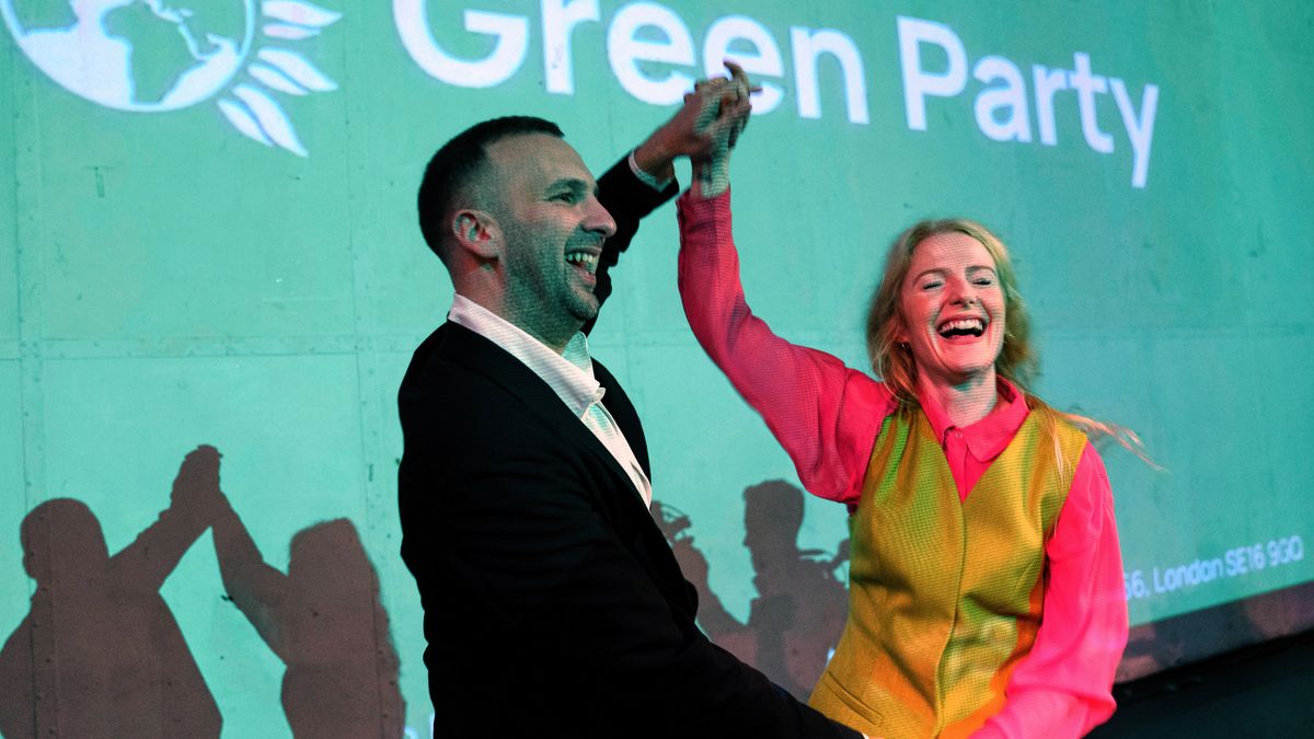 Green Party candidate Hannah Spencer, right, celebrates with party leader Zack Polanski at a volunteer thank you event after winning the Gorton and Denton by-election, Manchester, England, Friday, Feb. 27, 2026. (AP Photo/Jon Super)