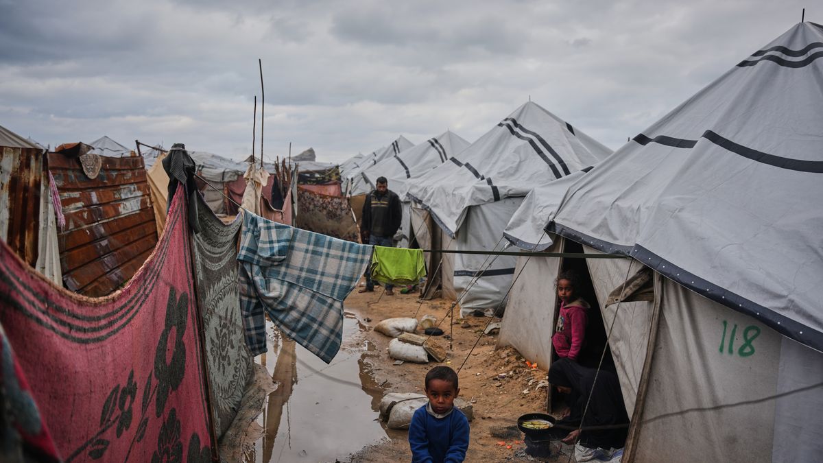 FILE - Nanaa Abu Jari cooks outside her tent after it was flooded by rainwater in Nuseirat, central Gaza Strip, Friday, Jan. 2, 2026. (AP Photo/Abdel Kareem Hana, File)