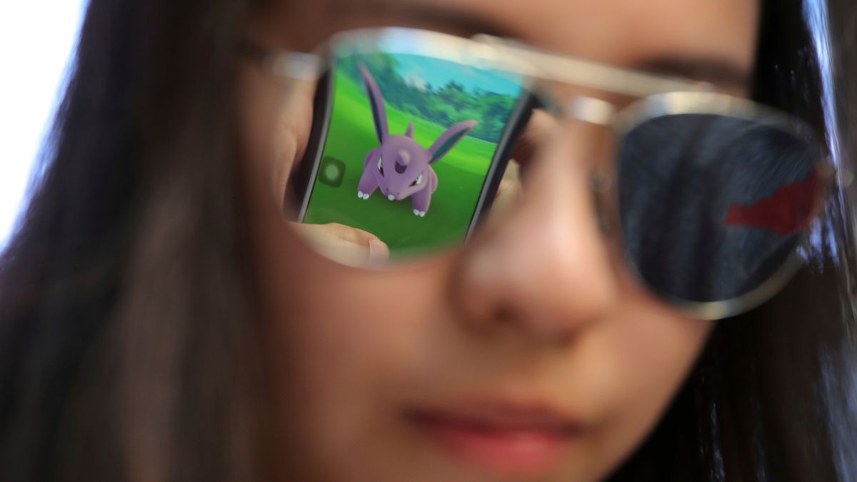 FILE - A mobile screen is reflected on a fan's sunglasses as she plays "Pokemon Go" in Hong Kong, on July 25, 2016. (AP Photo/Kin Cheung, File)