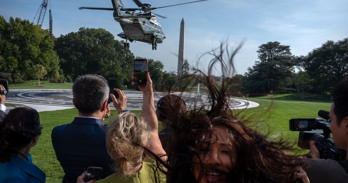 Members of the press watch as Marine One with President Donald Trump aboard lifts off from the South Lawn of the White