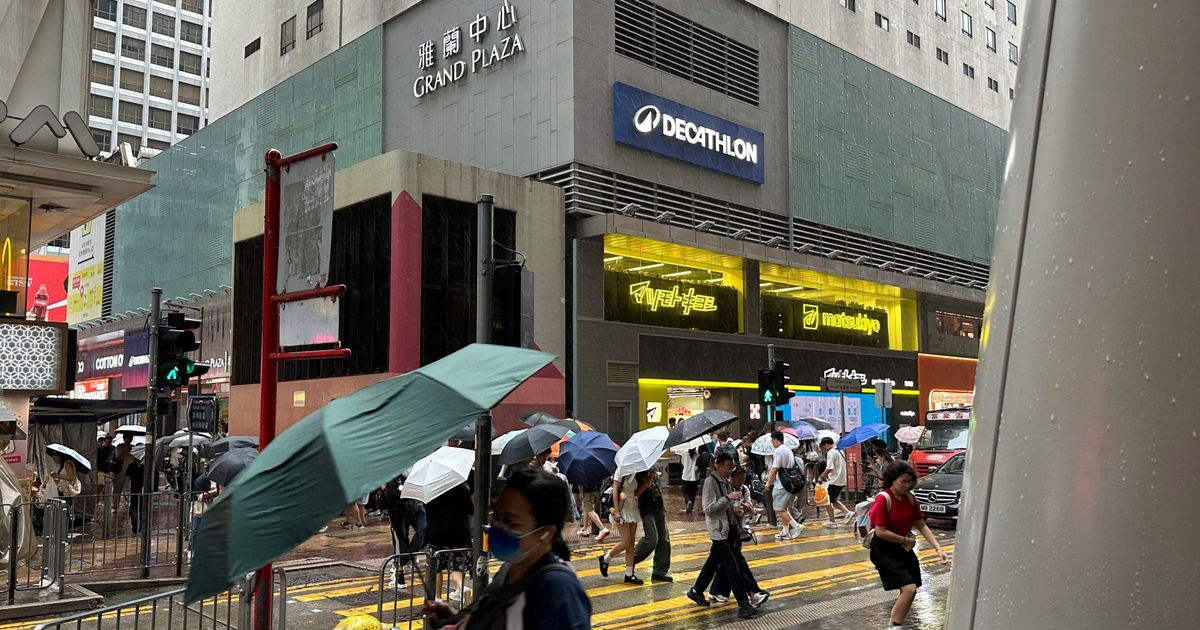 Passersby walk in Hong Kong's Mong Kok district under heavy rain and wind ahead of Typhoon Noul on Saturday, July 25, 2026