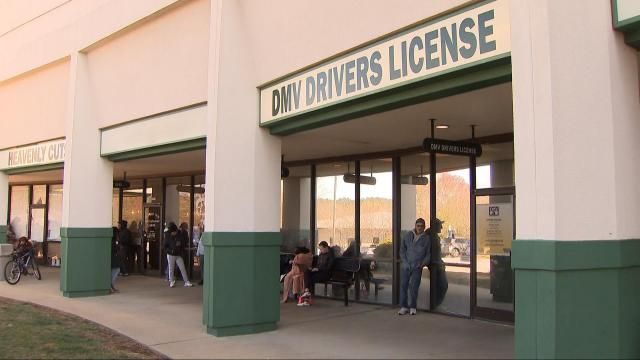 A file photo of people lined up outside of a North Carolina DMV office.