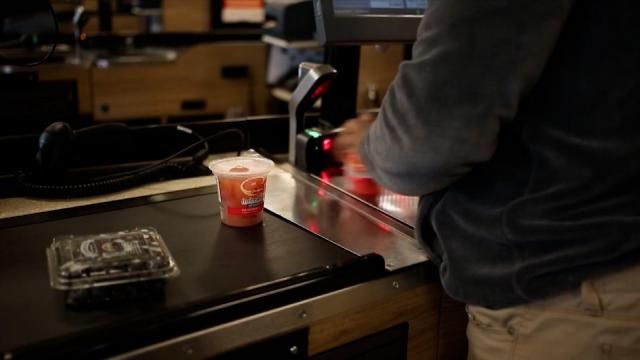 A file photo of a grocery store worker scanning items at the checkout.