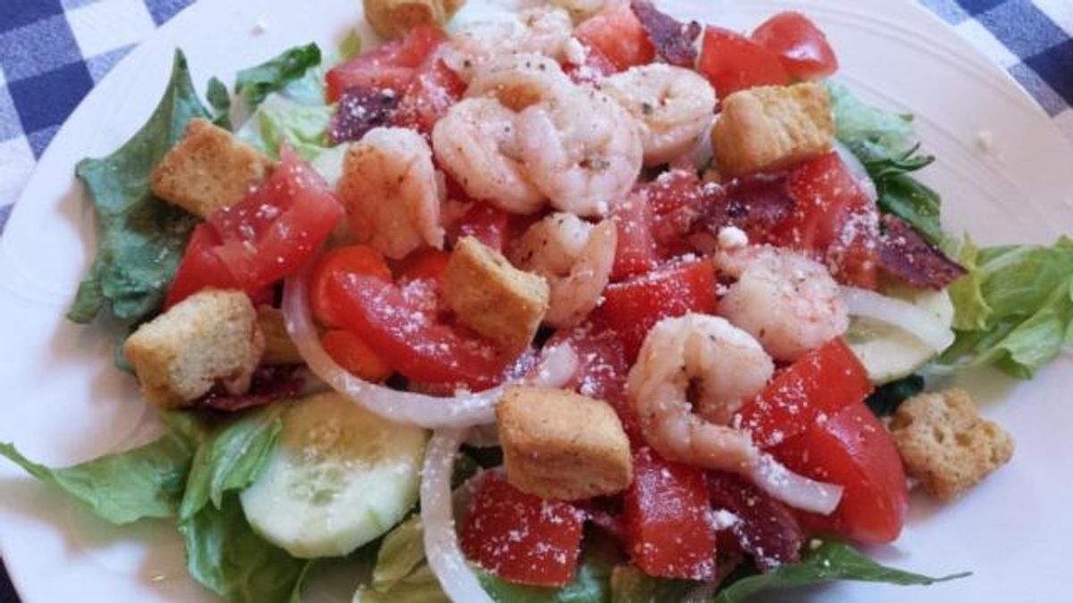 Garlic shrimp and turkey bacon on green salad