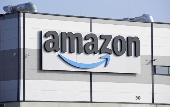 FILE - An Amazon company logo is seen on the facade of a company's building in Schoenefeld near Berlin, Germany, on March 18, 2022. Amazon and me<em></em>ta settled separate U.K. antitrust investigations by agreeing to stop practices that give them an unfair advantage over merchants and customers using their platforms, the watchdog said Friday. (AP Photo/Michael Sohn, File)