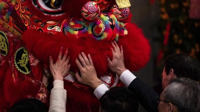 Guests touch a lion dance costume during a ceremony to mark the first trading day of the Year of the Dragon at the Hong Kong Exchanges (HKEX) in Hong Kong, Wednesday, Feb. 14, 2024. (AP Photo/Louise Delmotte) Guests touch a lion dance costume during a ceremony to mark the first trading day of the Year of the Dragon at the Hong Kong Exchanges (HKEX) in Hong Kong, Wednesday, Feb. 14, 2024. (AP Photo/Louise Delmotte)