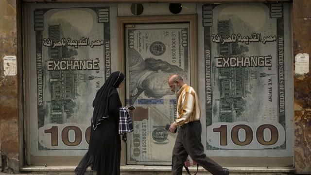 Egyptians walk past an exchange office in Cairo, Egypt, Wednesday, March 6, 2024. The Egyptian pound slipped sharply against the dollar on Wednesday after the Central Bank of Egypt raised its main interest rate and said it would allow the currency's exchange rate to be set by market forces. (AP Photo/Amr Nabil) Egyptians walk past an exchange office in Cairo, Egypt, Wednesday, March 6, 2024. The Egyptian pound slipped sharply against the dollar on Wednesday after the Central Bank of Egypt raised its main interest rate and said it would allow the currency's exchange rate to be set by market forces. (AP Photo/Amr Nabil)