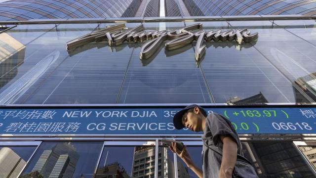 FILE - A pedestrian passes by a Hong Kong Stock Exchange electronic screen in Hong Kong on July 21, 2023. China stocks were mixed Wednesday, March 13, 2024, as the country scrambled to avoid major real estate developer bankruptcy. (AP Photo/Louise Delmotte, File) FILE - A pedestrian passes by a Hong Kong Stock Exchange electronic screen in Hong Kong on July 21, 2023. China stocks were mixed Wednesday, March 13, 2024, as the country scrambled to avoid major real estate developer bankruptcy. (AP Photo/Louise Delmotte, File)