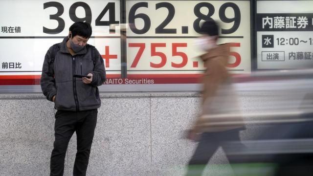 FILE - A person stands in front of an electronic stock board showing Japan's Nikkei 225 index at a securities firm Monday, March 18, 2024, in Tokyo. Shares are mixed in Asia after the Bank of Japan hiked its benchmark interest rate for the first time in 17 years, ending a longstanding negative rate policy.(AP Photo/Eugene Hoshiko, File) FILE - A person stands in front of an electronic stock board showing Japan's Nikkei 225 index at a securities firm Monday, March 18, 2024, in Tokyo. Shares are mixed in Asia after the Bank of Japan hiked its benchmark interest rate for the first time in 17 years, ending a longstanding negative rate policy.(AP Photo/Eugene Hoshiko, File)