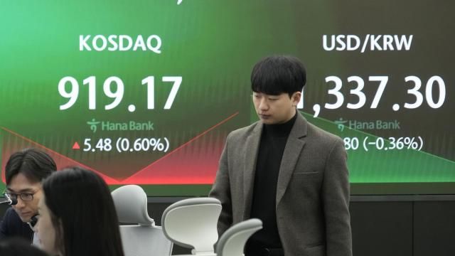 A currency trader passes by the screens showing the Korea Composite Stock Price Index (KOSPI), left, and the foreign exchange rate between U.S. dollar and South Korean won at the foreign exchange dealing room of the KEB Hana Bank headquarters in Seoul, South Korea, Tuesday, March 26, 2024. Asian shares were mixed in muted trading Tuesday, as buying in some markets was soon erased by profit-taking. (AP Photo/Ahn Young-joon) A currency trader passes by the screens showing the Korea Composite Stock Price Index (KOSPI), left, and the foreign exchange rate between U.S. dollar and South Korean won at the foreign exchange dealing room of the KEB Hana Bank headquarters in Seoul, South Korea, Tuesday, March 26, 2024. Asian shares were mixed in muted trading Tuesday, as buying in some markets was soon erased by profit-taking. (AP Photo/Ahn Young-joon)