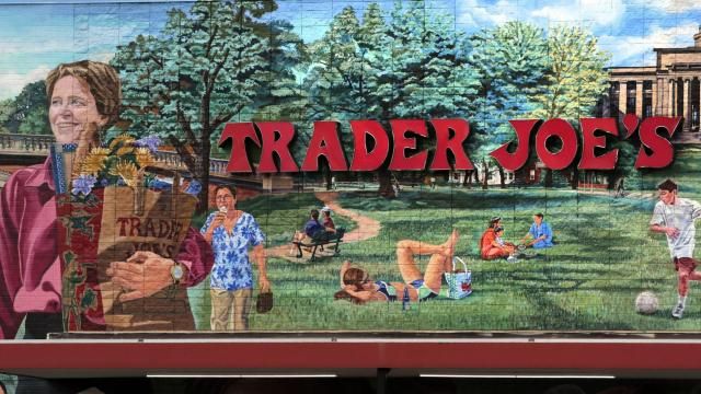 FILE - The Trader Joe's logo hangs on a mural, Aug. 13, 2019, in Cambridge, Mass. Trader Joe's recently upped the price to 23 cents for a single banana, marking a 4-cent increase from the grocer's previous going rate for the fruit that remained unchanged for over 20 years. (AP Photo/Charles Krupa, File) FILE - The Trader Joe's logo hangs on a mural, Aug. 13, 2019, in Cambridge, Mass. Trader Joe's recently upped the price to 23 cents for a single banana, marking a 4-cent increase from the grocer's previous going rate for the fruit that remained unchanged for over 20 years. (AP Photo/Charles Krupa, File)