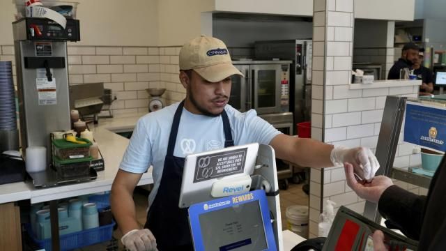 An employee collects payment at an Auntie Anne's and Cinnabon store in Livermore, Calif., Thursday, March 28, 2024. He's among hundreds of thousands of California fast-food workers who will be paid at least $20 an hour starting Monday, April 1. (AP Photo/Terry Chea) An employee collects payment at an Auntie Anne's and Cinnabon store in Livermore, Calif., Thursday, March 28, 2024. He's among hundreds of thousands of California fast-food workers who will be paid at least $20 an hour starting Monday, April 1. (AP Photo/Terry Chea)