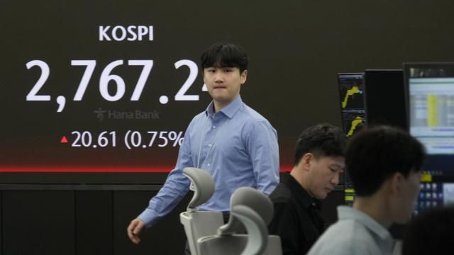 A currency trader walks by the screen showing the Korea Composite Stock Price Index (KOSPI) at the foreign exchange dealing room of the KEB Hana Bank headquarters in Seoul, South Korea, Monday, April 1, 2024. Asian shares were mixed Monday, with Shanghai gaining 1% after surveys showed improvements in manufacturing conditions in China. (AP Photo/Ahn Young-joon) A currency trader walks by the screen showing the Korea Composite Stock Price Index (KOSPI) at the foreign exchange dealing room of the KEB Hana Bank headquarters in Seoul, South Korea, Monday, April 1, 2024. Asian shares were mixed Monday, with Shanghai gaining 1% after surveys showed improvements in manufacturing conditions in China. (AP Photo/Ahn Young-joon)