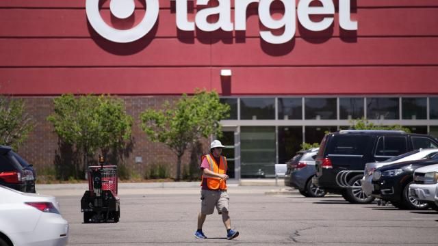 FILE - A worker collects shopping carts in the parking lot of a Target store June 9, 2021, in Highlands Ranch, Colo. Target says it's cutting prices on about 5,000 food, beverage and household essential items, becoming the latest company to shift its pricing strategy as consumers pay closer attention to how they spend their money amid inflation concerns.(AP Photo/David Zalubowski, File)