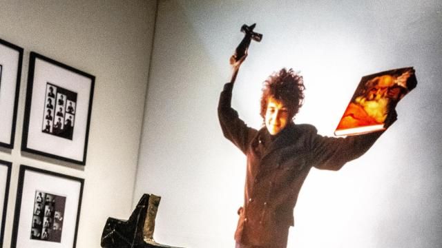 Original props belonging to the photographer Jerry Schatzberg sit before a photograph of Bob Dylan holding them during a photoshoot, at the Bob Dylan Center in Tulsa, Okla., April 30, 2022. A new space to display Dylan’s vast archive, celebrates one of the world’s most elusive creators, and gives visitors a close-up look at notebooks and fan mail. (Joseph Rushmore/The New York Times) Original props belonging to the photographer Jerry Schatzberg sit before a photograph of Bob Dylan holding them during a photoshoot, at the Bob Dylan Center in Tulsa, Okla., April 30, 2022. A new space to display Dylan’s vast archive, celebrates one of the world’s most elusive creators, and gives visitors a close-up look at notebooks and fan mail. (Joseph Rushmore/The New York Times)
