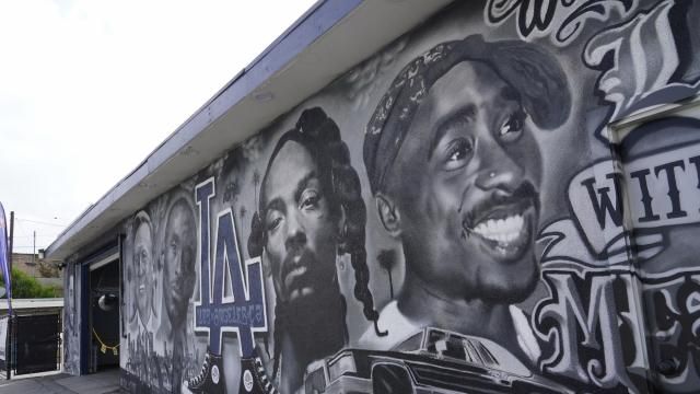 A portion of a mural by artist sloe_motions depicting Oscar De La Hoya, Vin Scully, Kobe Bryant, Snoop Dogg, and Tupac Shakur is seen on the side of Speedy Auto Tint on Friday, Sept. 29, 2023, in Bellflower, Calif. (AP Photo/Chris Pizzello)