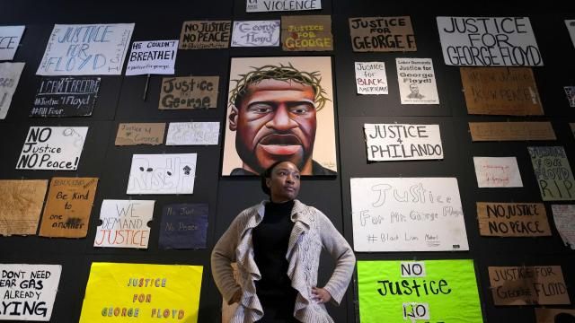 Jeanelle Austin, director of the George Floyd Global Memorial, pauses during the installation of "Twin Flames: The George Floyd Uprising from Minneapolis to Phoenix," at Arizona State University Art Museum, Friday, Jan. 12, 2024, in Tempe, Ariz. For months after George Floyd was killed by police in May 2020, people from around the world traveled to the site of his murder in Minneapolis and left signs, paintings and poems to memorialize the man whose death reignited a movement against systemic racism. Now hundreds of those artifacts are being displayed at an exhibit at the Arizona State University Art Museum. (AP Photo/Ross D. Franklin) Jeanelle Austin, director of the George Floyd Global Memorial, pauses during the installation of "Twin Flames: The George Floyd Uprising from Minneapolis to Phoenix," at Arizona State University Art Museum, Friday, Jan. 12, 2024, in Tempe, Ariz. For months after George Floyd was killed by police in May 2020, people from around the world traveled to the site of his murder in Minneapolis and left signs, paintings and poems to memorialize the man whose death reignited a movement against systemic racism. Now hundreds of those artifacts are being displayed at an exhibit at the Arizona State University Art Museum. (AP Photo/Ross D. Franklin)
