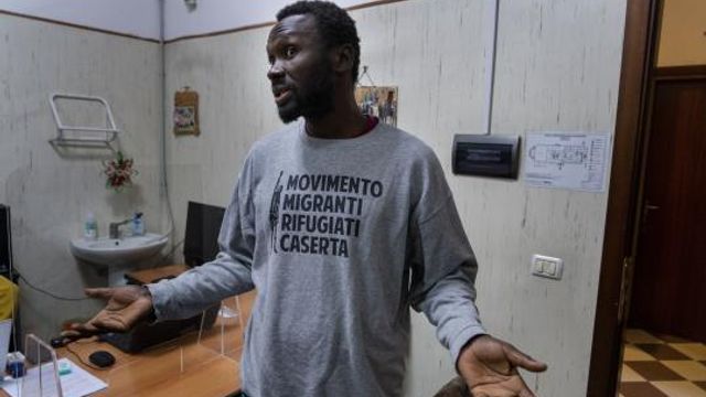 Mamadou Kouassi, left, a migrant who made the journey from his native Ivory Coast to Italy in 2006, talks to The Associated Press during an interview in a migrant center in Castel Volturno, southern Italy, where he now dedicates his life to working with migrants, Thursday, Feb. 1, 2024. Kouassi's odyssey through Africa inspired the movie Io Capitano (Me Captain) to Italian director Matteo Garrone and is among the nominees for the 2024 96th Academy Awards in the International Feature Film category. (AP Photo/Domenico Stinellis) Mamadou Kouassi, left, a migrant who made the journey from his native Ivory Coast to Italy in 2006, talks to The Associated Press during an interview in a migrant center in Castel Volturno, southern Italy, where he now dedicates his life to working with migrants, Thursday, Feb. 1, 2024. Kouassi's odyssey through Africa inspired the movie Io Capitano (Me Captain) to Italian director Matteo Garrone and is among the nominees for the 2024 96th Academy Awards in the International Feature Film category. (AP Photo/Domenico Stinellis)