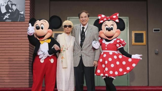 FILE - Mickey Mouse, from left, Elizabeth Gluck, Richard M. Sherman and Minnie Mouse pose for a photo at the ceremony honoring the Sherman Brothers with the rename of Disney Studios Soundstage A at the world premiere of Disney's "Christopher Robin" at the Walt Disney Studios, July 30, 2018, in Burbank, Calif. Sherman, one half of the prolific, award-winning pair of brothers who helped form millions of childhoods by penning classic Disney tunes, died Saturday, May 25, 2024. He was 95. (Photo by Willy Sanjuan/Invision/AP, File)