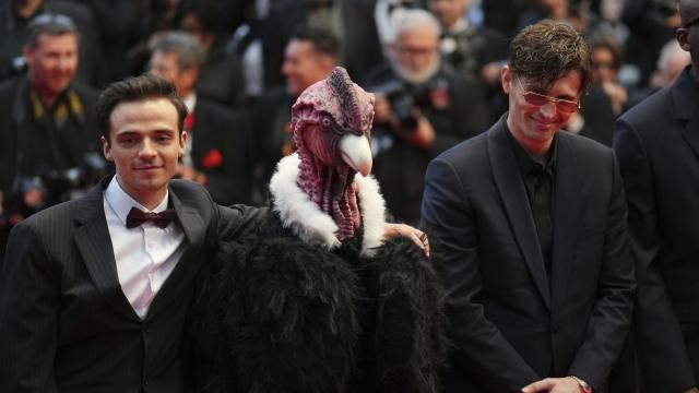 Raphael Quenard, left, and Hugo David, right, pose with a person dressed in bird costume upon arrival at the premiere of the film 'Die, My Love' at the 78th international film festival, Cannes, southern France, Saturday, May 17, 2025. (Photo by Lewis Joly/Invision/AP)