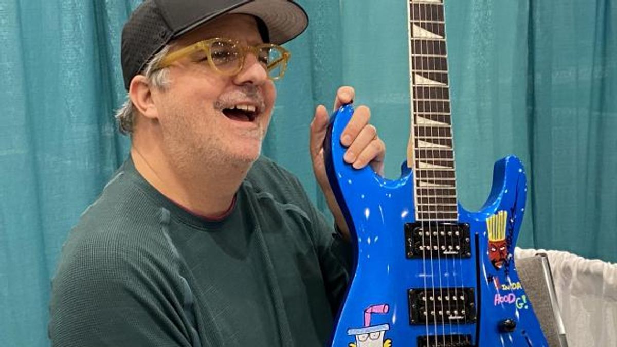 Dana Snyder holding an autographed guitar