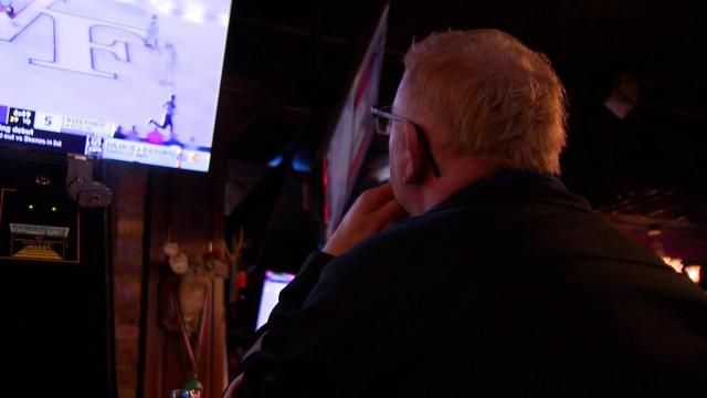 A fan watches a college basketball game at a sports bar in Raleigh.