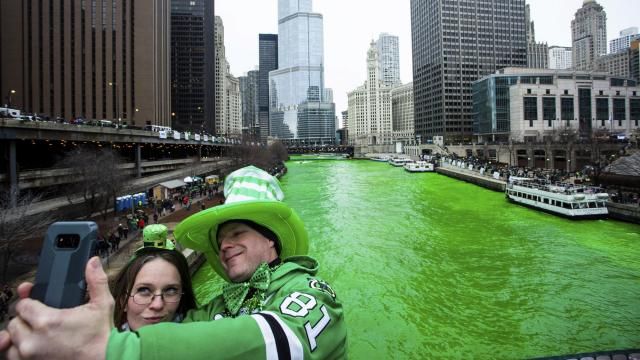 FILE - Stacey Peterson and Kevin McGuire take a selfie in front of the green Chicago River to celebrate St. Patrick's Day, Saturday, March 17, 2018. The Chicago River has been dyed a bright shade of green, kicking off the city's St. Patrick's Day festivities. The day honoring the patron saint of Ireland is a global celebration of Irish heritage. And nowhere is that more so than in the United States, where parades take place in cities around the country and all kinds of foods and drinks are given an emerald hue. (James Foster/Chicago Sun-Times via AP, File) FILE - Stacey Peterson and Kevin McGuire take a selfie in front of the green Chicago River to celebrate St. Patrick's Day, Saturday, March 17, 2018. The Chicago River has been dyed a bright shade of green, kicking off the city's St. Patrick's Day festivities. The day honoring the patron saint of Ireland is a global celebration of Irish heritage. And nowhere is that more so than in the United States, where parades take place in cities around the country and all kinds of foods and drinks are given an emerald hue. (James Foster/Chicago Sun-Times via AP, File)