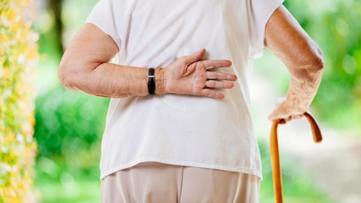Elderly Woman Outdoors With Back Pain