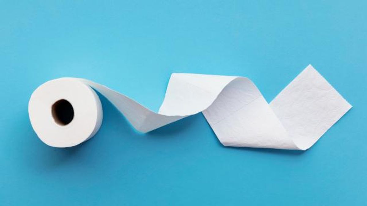 A single roll of toilet paper unrolled on a blue background