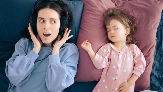 Mom listens to podcast while child is asleep (Adobe Stock) Mom listens to podcast while child is asleep (Adobe Stock)