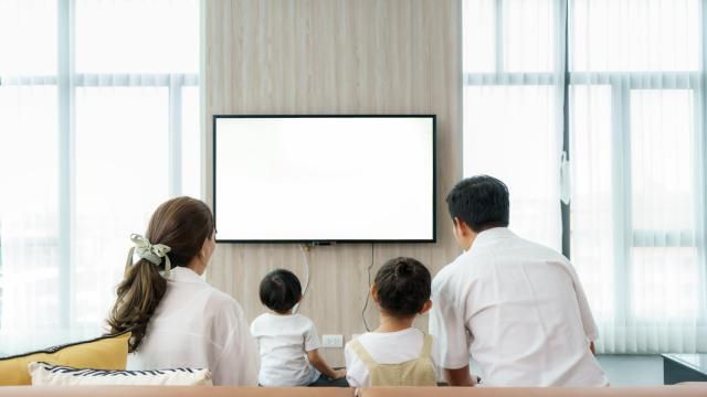 Family watching TV together (Adobe Stock)