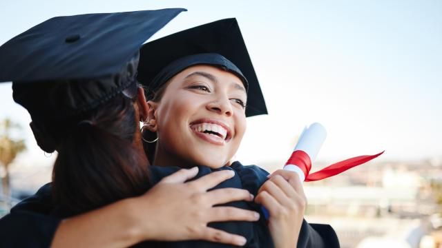 College graduates hug after receiving degrees (Adobe Stock)