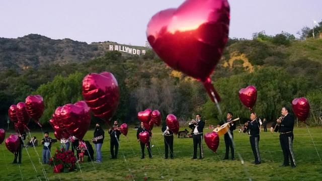 FILE - A Mexican Mariachi band surrounded by heart-shaped balloons awaits the arrival of a couple's wedding proposal ceremony at the Lake Hollywood Park in Los Angeles, on Feb. 14, 2022. This is the first Valentine's Day since the U.S. surgeon general issued a public health advisory declaring loneliness and isolation an epidemic with dire consequences. (AP Photo/Damian Dovarganes, File) FILE - A Mexican Mariachi band surrounded by heart-shaped balloons awaits the arrival of a couple's wedding proposal ceremony at the Lake Hollywood Park in Los Angeles, on Feb. 14, 2022. This is the first Valentine's Day since the U.S. surgeon general issued a public health advisory declaring loneliness and isolation an epidemic with dire consequences. (AP Photo/Damian Dovarganes, File)