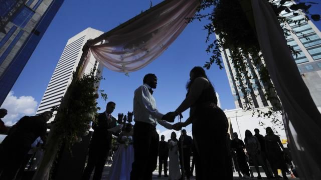 FILE - A couple holds hands as they are married by a county clerk during a Valentine's Day group wedding ceremony on the steps of the Dade County Courthouse in Miami, Wednesday, Feb. 14, 2024. U.S. marriages have rebounded to pre-pandemic levels with nearly 2.1 million in 2022, a 4% increase from the year before, the Centers for Disease Control and Prevention said in a report published Friday, March 15, 2024. (AP Photo/Rebecca Blackwell, File) FILE - A couple holds hands as they are married by a county clerk during a Valentine's Day group wedding ceremony on the steps of the Dade County Courthouse in Miami, Wednesday, Feb. 14, 2024. U.S. marriages have rebounded to pre-pandemic levels with nearly 2.1 million in 2022, a 4% increase from the year before, the Centers for Disease Control and Prevention said in a report published Friday, March 15, 2024. (AP Photo/Rebecca Blackwell, File)
