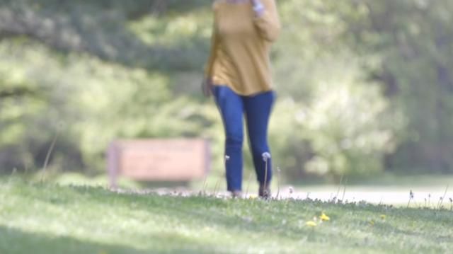 A woman walks at a park.