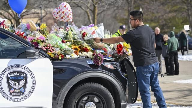 Crasto Cruz Reyes of Austin, Minn., places flowers at one of the three memorial vehicles in front of the Burnsville Police Department in Burnsville, Minn., Monday, Feb. 19, 2024. Two police officers and a firefighter who responded to a domestic situation at a suburban Minneapolis home were killed early Sunday during a standoff by a heavily armed man who shot at police from the home where seven children were also inside. (Craig Lassig/Pioneer Press via AP) Crasto Cruz Reyes of Austin, Minn., places flowers at one of the three memorial vehicles in front of the Burnsville Police Department in Burnsville, Minn., Monday, Feb. 19, 2024. Two police officers and a firefighter who responded to a domestic situation at a suburban Minneapolis home were killed early Sunday during a standoff by a heavily armed man who shot at police from the home where seven children were also inside. (Craig Lassig/Pioneer Press via AP)