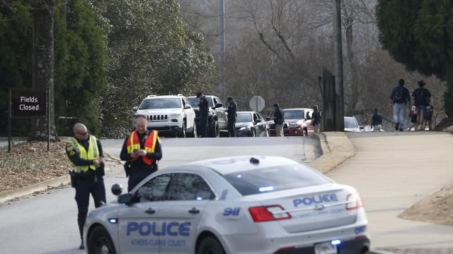 Athens-Clarke County police block traffic and investigate at the UGA intramural Fields after the body of a women was found with found with visible injuries was found in the woods around Lake Herrick in Athens, Ga., on Thursday, Feb. 22, 2024. (Joshua L. Jones/Athens Banner-Herald via AP)