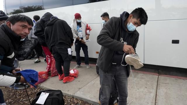 Migrants unload their items off a bus as they arrive at a bus stop after leaving a processing facility, Friday, Feb. 23, 2024, in San Diego. Hundreds of migrants were dropped off Friday at a sidewalk bus stop amid office parks in San Diego with notices to appear in immigration court after local government funding for a reception center ran out of money sooner than expected. (AP Photo/Gregory Bull) Migrants unload their items off a bus as they arrive at a bus stop after leaving a processing facility, Friday, Feb. 23, 2024, in San Diego. Hundreds of migrants were dropped off Friday at a sidewalk bus stop amid office parks in San Diego with notices to appear in immigration court after local government funding for a reception center ran out of money sooner than expected. (AP Photo/Gregory Bull)