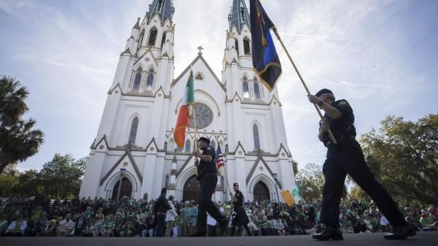 FILE - Participants carry flags past the Cathedral Basilica of St. John the Baptist while marching in the St. Patrick's Day parade, March 17, 2023, in historic downtown Savannah, Ga. Savannah, Georgia's oldest city, is planning a supersized celebration as it marks the 200th anniversary of its beloved St. Patrick's Day parade. City Manager Jay Melder says he's expecting historic crowds for the Irish-themed parade Saturday, March 16, 2024. (AP Photo/Stephen B. Morton) FILE - Participants carry flags past the Cathedral Basilica of St. John the Baptist while marching in the St. Patrick's Day parade, March 17, 2023, in historic downtown Savannah, Ga. Savannah, Georgia's oldest city, is planning a supersized celebration as it marks the 200th anniversary of its beloved St. Patrick's Day parade. City Manager Jay Melder says he's expecting historic crowds for the Irish-themed parade Saturday, March 16, 2024. (AP Photo/Stephen B. Morton)