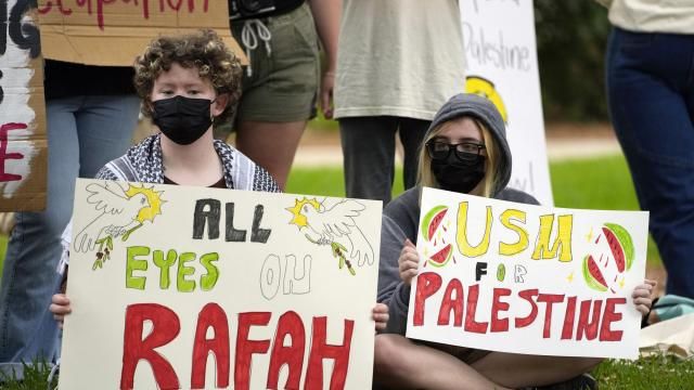 BJ Brumley, left, and fellow University of Southern Mississippi student Vinny Halsey, hold Pro-Palestinian signs protesting the Israel Hamas war in Gaza, during an hour-long silent protest on the school's campus, Tuesday, May 7, 2024, in Hattiesburg, Miss. The group of almost 50 demonstrators drew no counter protesters or hecklers. (AP Photo/Rogelio V. Solis)