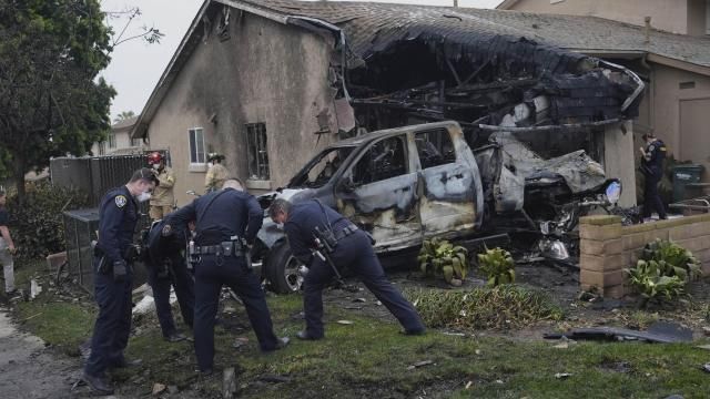 Authorities work the scene where a small plane crashed into a San Diego neighborhood, setting several homes on fire and forcing evacuations along several blocks early Thursday, May 22, 2025. (AP Photo/Gregory Bull)