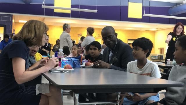 Cindy Long, administrator of the U.S. Department of Agriculture's Food and Nutrition Service (left), and Wake County Public School System Superintendent Robert Taylor (right) eat lunch with fourth-graders at Kingswood Elementary on June 4, 2024. Long and Taylor met with state and local leaders to talk about improving access to healthy meals for schoolchildren. Emily Walkenhorst/WRAL