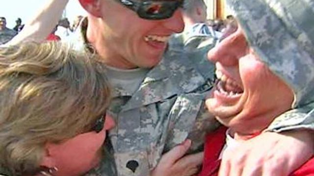 Guardsmen fly home to tears, hugs and flags