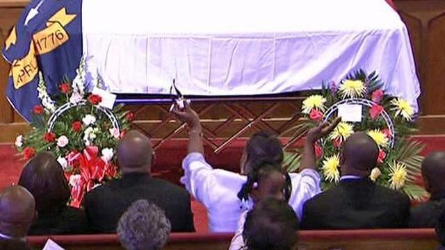 Mourners cheer Malone's life of service